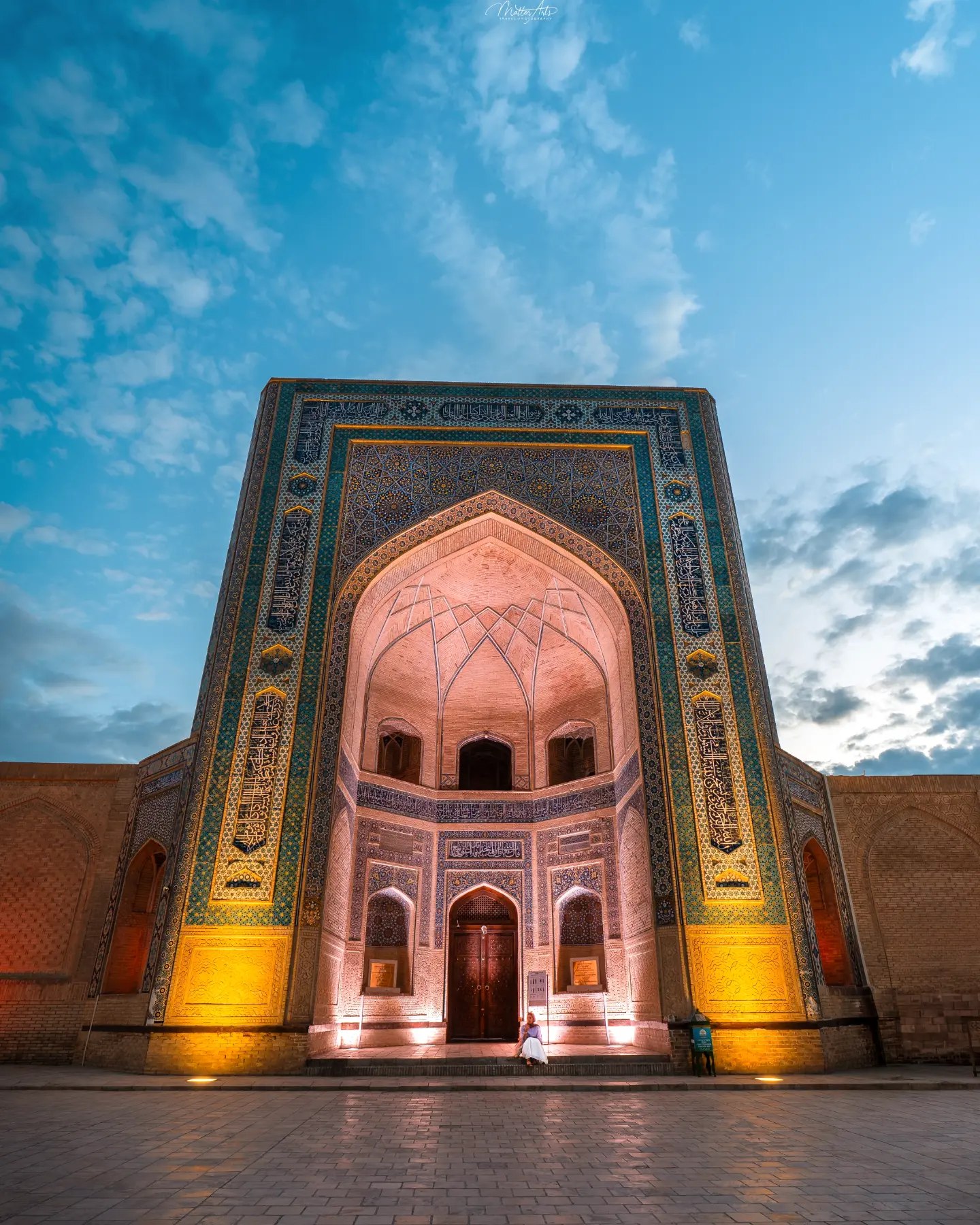 A blue tiled dome with intricate patterns above a mosque entrance